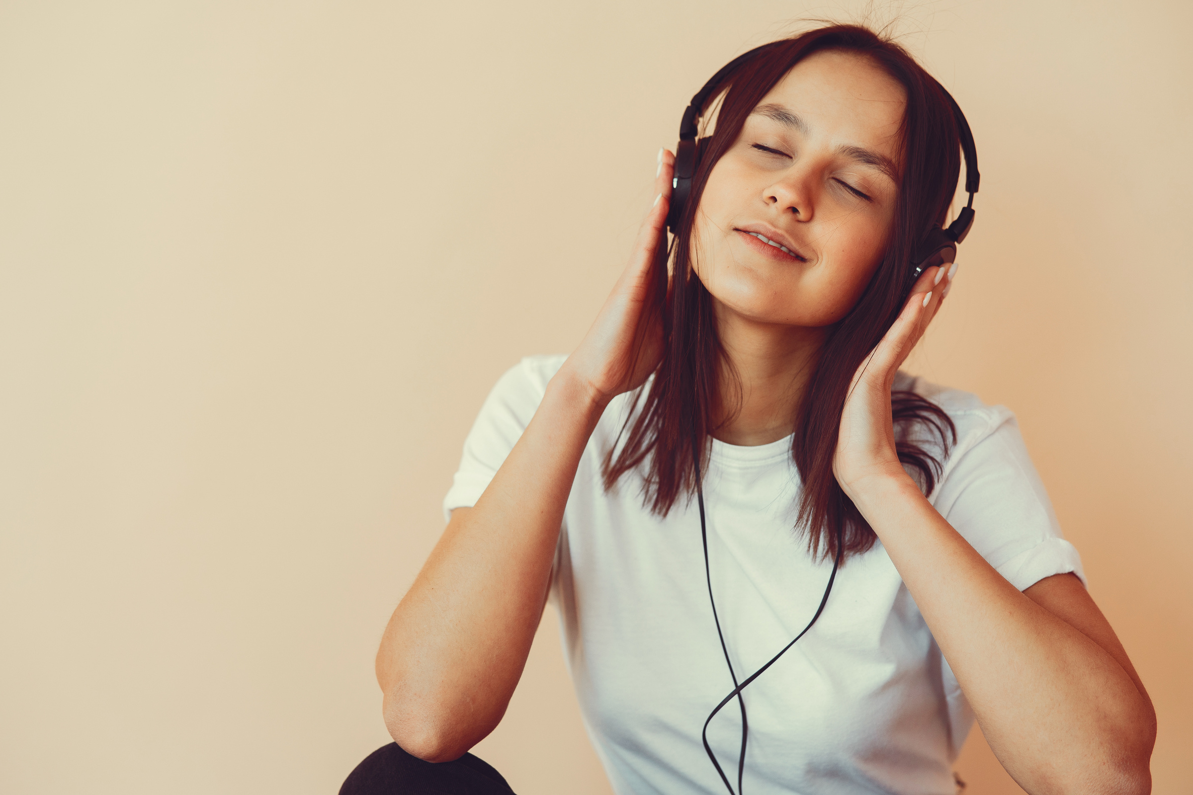 Dreamy young woman listening to music in headphones